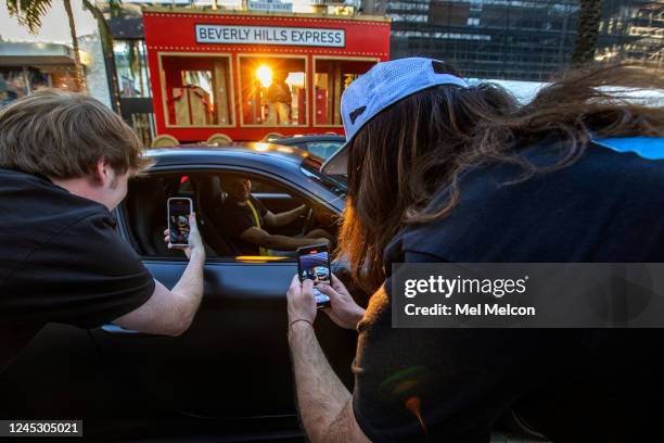 Daniel MacDonald left, and his producer Blake Thompson use their iPhones to take video of a man stopped at a red light on Rodeo Drive in Beverly...