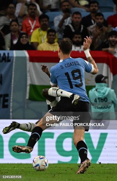 Uruguay's defender Sebastian Coates collides with Ghana's forward Kamaldeen Sulemana during the Qatar 2022 World Cup Group H football match between...