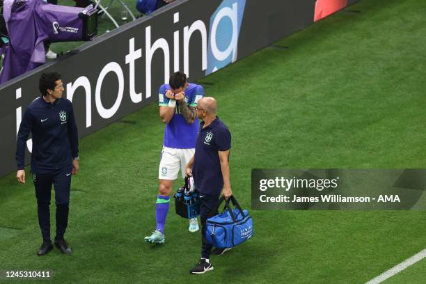 Alex Telles of Brazil leaves the field due to injury during the FIFA World Cup Qatar 2022 Group G match between Cameroon and Brazil at Lusail Stadium...