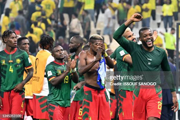 Cameroon's midfielder Olivier Ntcham and teammates celebrate on the pitch after the Qatar 2022 World Cup Group G football match between Cameroon and...