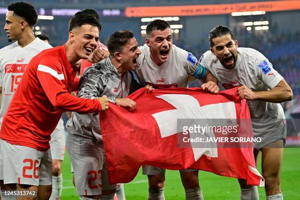 Players of Switzerland pose for a picture as they celebrate defeating Serbia 3-2 and qualifying to the next round of the tournament, at the end of...