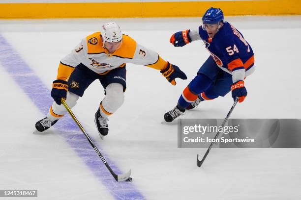 Nashville Predators Defenceman Jeremy Lauzon and New York Islanders Center Cole Bardreau battle for the puck during the first period of the National...