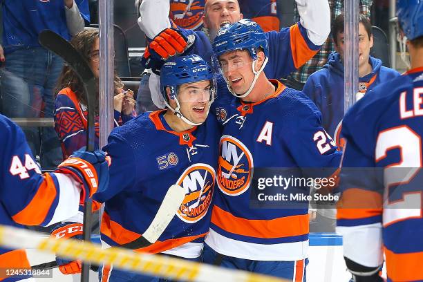 Mathew Barzal of the New York Islanders is congratulated by Brock Nelson after scoring a goal against the Nashville Predators during the third period...