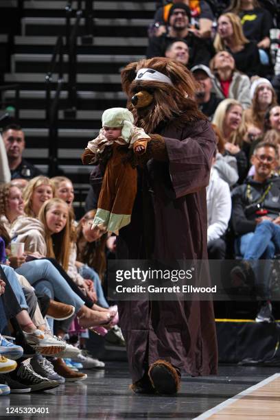 Mascot Jazz Bear of the Utah Jazz walks on to the court with a fan during the game against the Indiana Pacers on December 2, 2022 at Vivint SmartHome...
