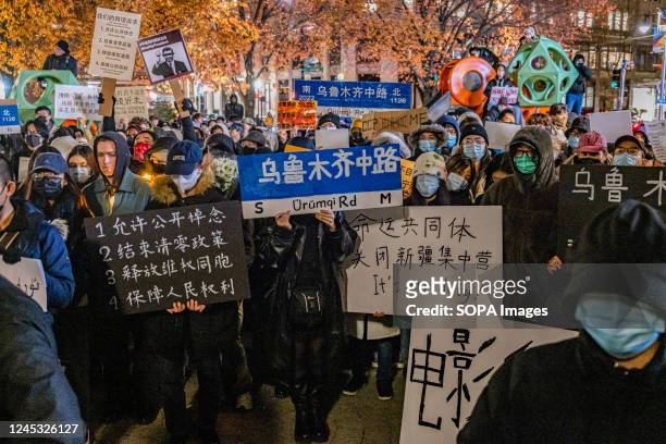 Demonstrators hold white papers and placards during a protest in solidarity with Urumqi people at Tiananmen Memorial. Over 400 people participate in...