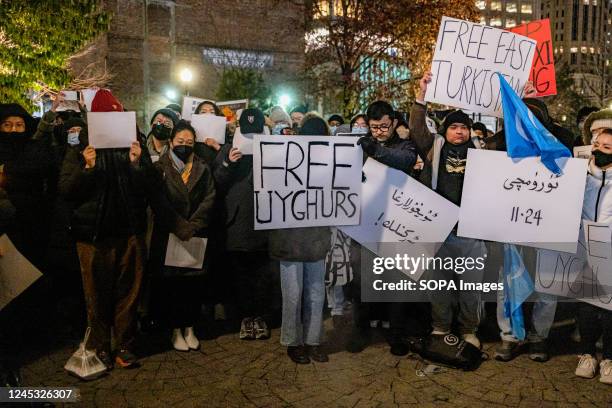 Demonstrators hold placards that read "Free Uyghurs" and "Free Turkistan" during a protest in solidarity with Urumqi people at Tiananmen Memorial....