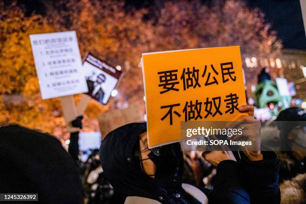 Demonstrator holds a placard that reads "Be a citizen, not a slave" during a protest in solidarity with Urumqi people at Tiananmen Memorial. Over 400...