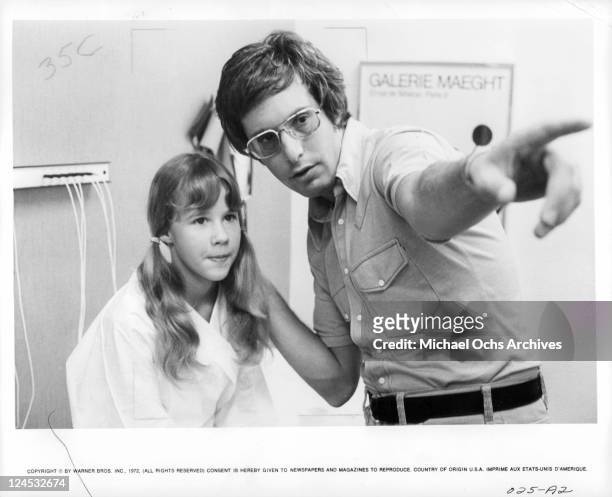 Linda Blair listens to instructions being given to her by director William Friedkin in a scene from the film 'The Exorcist', 1973.