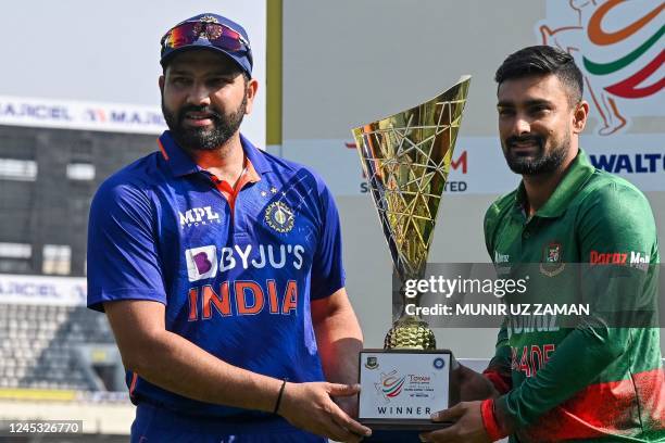 India's cricket captain Rohit Sharma and his counterpart Liton Das hold the tournament trophy during a trophy unveiling program after a practice...