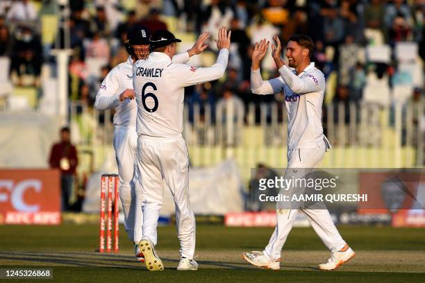 England's Will Jaks celebrates with teammates after taking the wicket of Pakistan's captain Babar Azam during the third day of the first cricket Test...