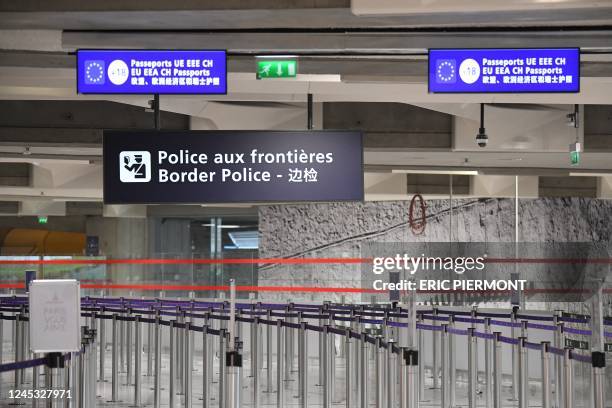 Photograph taken on December 3, 2022 shows empty waiting lines at the border police control points at Roissy-Charles de Gaulle Airport, north of...