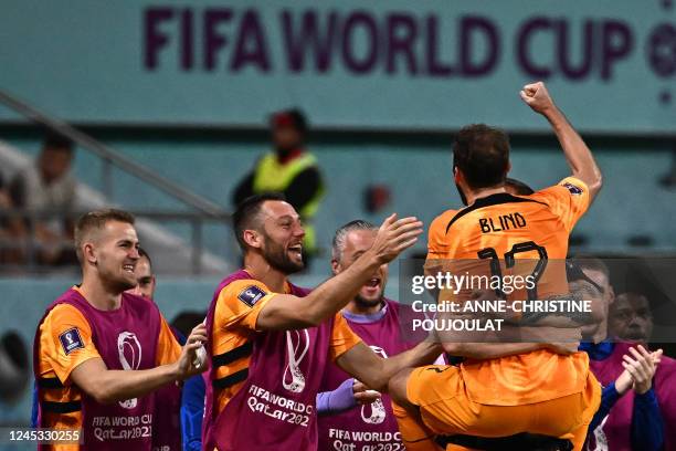 Netherlands' defender Daley Blind celebrates with teammates after he scored his team's second goal during the Qatar 2022 World Cup round of 16...