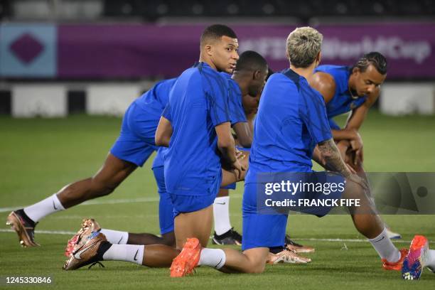 France's forward Kylian Mbappe and France's forward Antoine Griezmann speak together as they attend a training session at the Al Sadd SC training...