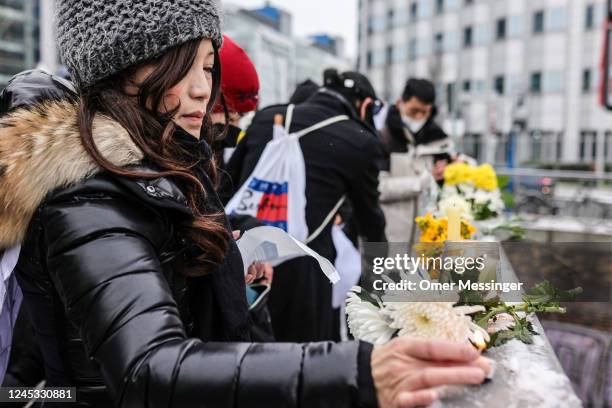 Demonstrator lights a candle at an onsite makeshift memorial, during a protest in front of the Chinese Embassy in solidarity with protesters in China...