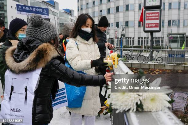 Demonstrator lights a candle at an onsite makeshift memorial, during a protest in front of the Chinese Embassy in solidarity with protesters in China...