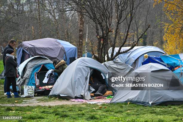 People hold clothe from luggage at the migrant basement implanted in front of the Strasbourg city hall in Strasbourg, eastern France, on December 3,...