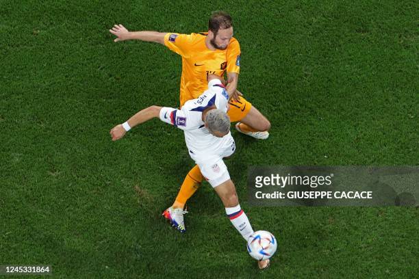 Netherlands' defender Daley Blind and USA's defender Sergino Dest fight for the ball during the Qatar 2022 World Cup round of 16 football match...