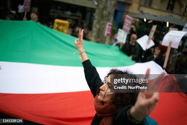 Woman reacts near a giant Iranian flag. Iranians of Toulouse organized a protest in Toulouse in solidarity with women and protesters in Iran,...