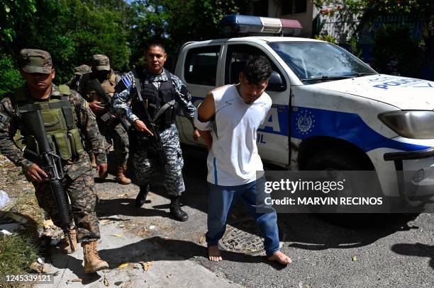 Police and soldiers escort people captured during an operation against gang members in Soyapango, El Salvador, on December 3, 2022. - Around 10,000...