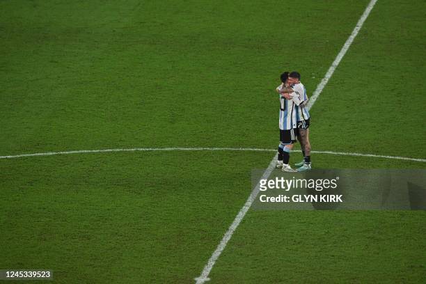 Argentina's forward Lionel Messi hugs Argentina's midfielder Rodrigo De Paul as the celebrate the team's victory at the end of the Qatar 2022 World...