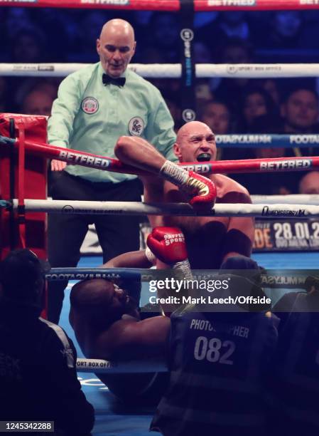 Fury hangs on to the ropes as Chisora is on the floor during the Tyson Fury v Derek Chisora Heavyweight Boxing at Tottenham Hotspur Stadium on...