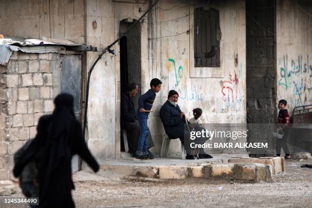 Internally displaced Syrians sit by a road at a camp near a position held by Turkey-backed Syrian fighters in al-Kraydiyeh area, on the frontline...