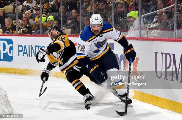 Justin Faulk of the St. Louis Blues handles the puck against Jason Zucker of the Pittsburgh Penguins at PPG PAINTS Arena on December 3, 2022 in...