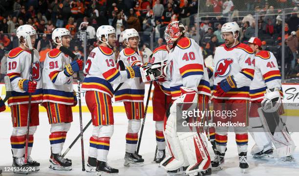 Goaltender Akria Schmid and Nico Hischier of the New Jersey Devils celebrate with teammates after defeating the Philadelphia Flyers 3-2 at the Wells...