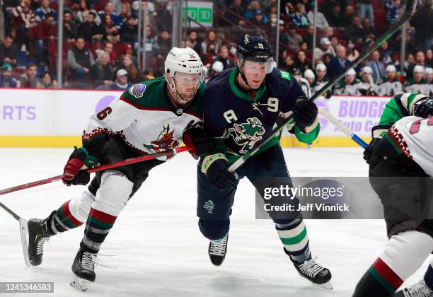 Miller of the Vancouver Canucks gets checked by Christian Fischer of the Arizona Coyotes during the first period of their NHL game against the...