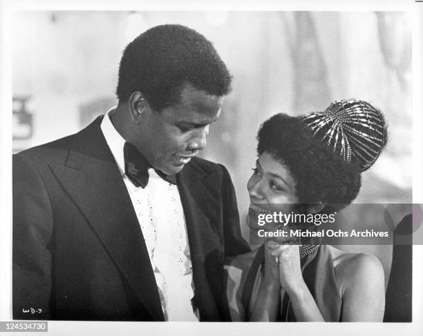 Sidney Poitier and Esther Anderson gazing into each others eyes in a scene from the film 'A Warm December', 1973.