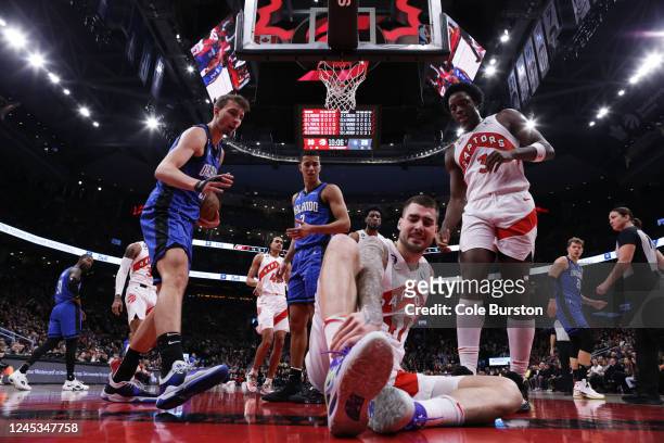 Franz Wagner and Caleb Houstan of the Orlando Magic react as Juancho Hernangomez of the Toronto Raptors falls to the floor during the first half of...