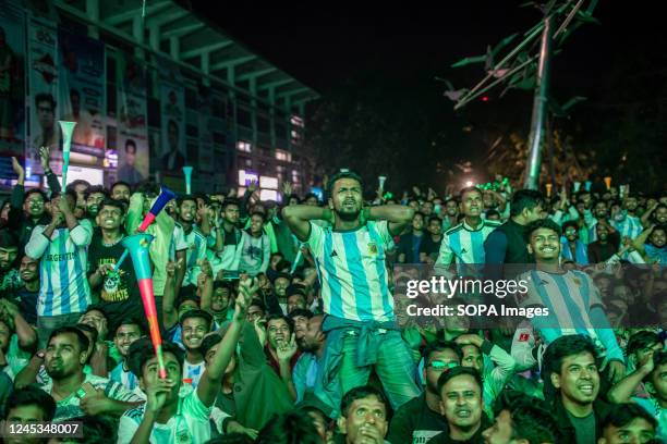 Football fans react as they watch the Qatar 2022 World Cup football match between Argentina and Australia on a big screen at Dhaka University campus....