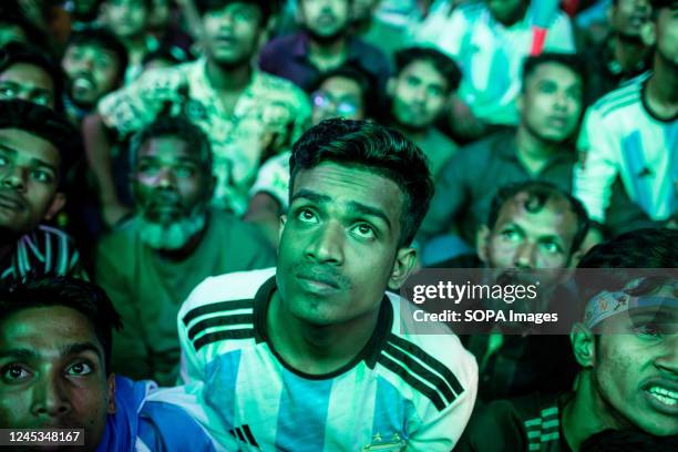 People watching a Qatar 2022 World Cup football match between Argentina and Australia on a big screen at Dhaka University area. .