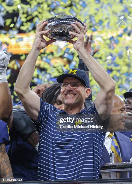 Head coach Jim Harbaugh of the Michigan Wolverines holds the Big Ten trophy following the game against the Purdue Boilermakers in the Big Ten...