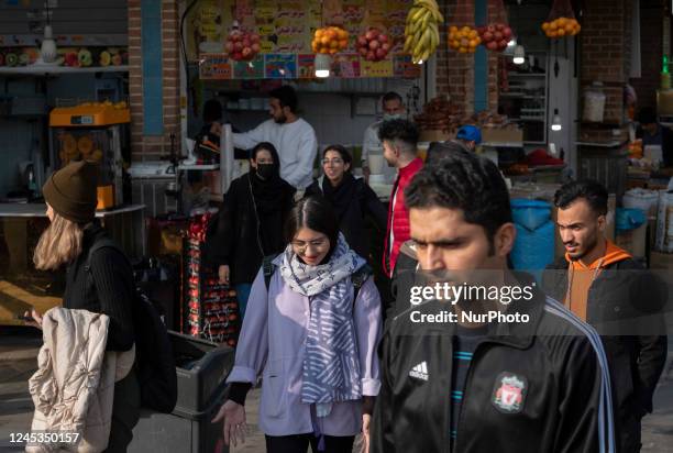 Group of Iranian youths walk along a street-side near Tehran Grand Bazaar , December 3, 2022.