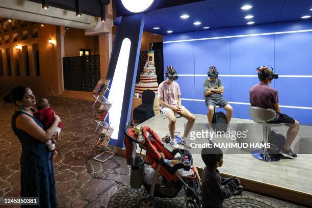 Young football fans watch a five-minute virtual reality tour of Islam, near Doha's Blue Mosque, during the Qatar 2022 World Cup football tournament,...