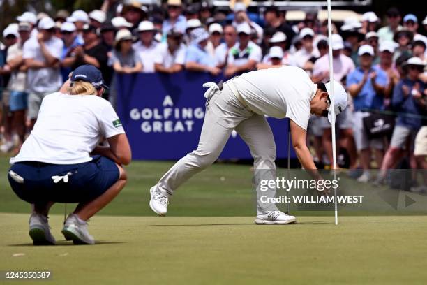 South Korea's Shin Ji-yai retrieves her ball from the hole as South Africa's Ashleigh Buhai looks on during the final round of the Women's Australian...