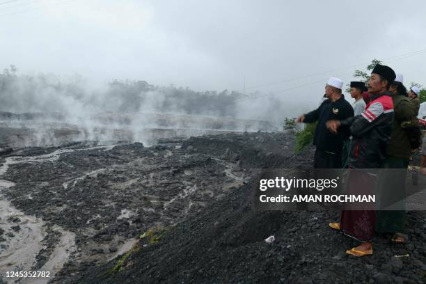 Villagers watch hot smoke from the ground at the Curah Kobokan village following Mount Semeru's volcanic eruption in Lumajang, East Java on December...