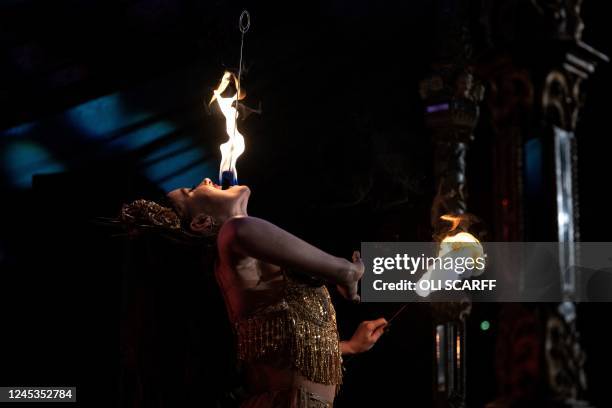 Penny Valent, a member of The Black Cat Cabaret, performs her fire act in The Spiegeltent venue in the centre of the Piece Hall in Halifax, northern...