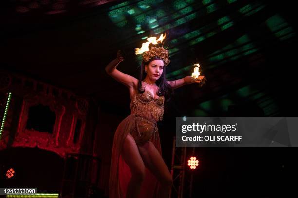 Penny Valent, a member of The Black Cat Cabaret, performs her fire act in The Spiegeltent venue in the centre of the Piece Hall in Halifax, northern...