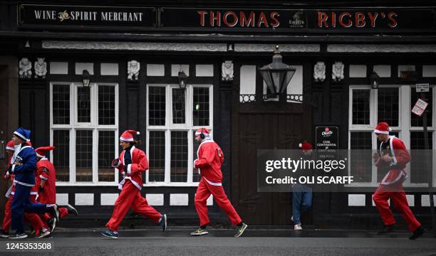 Runners dressed in Father Christmas attire take part in the annual five-kilometre Santa Dash in Liverpool, northwest England, on December 4, 2022. -...