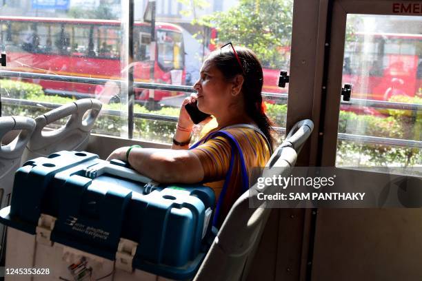 Polling official speaks on phone as she boards a bus carrying election related materials and Voter Verifiable Paper Audit Trail at dispatch centre a...