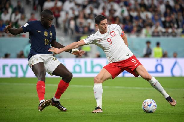 France's defender Dayot Upamecano fights for the ball with Poland's forward Robert Lewandowski during the Qatar 2022 World Cup round of 16 football...