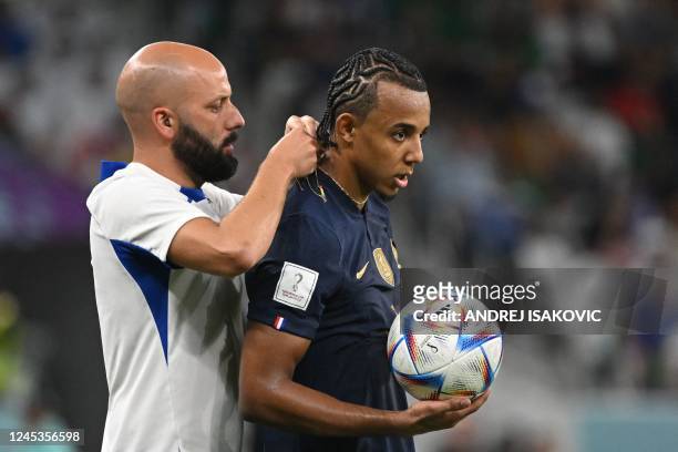 France's defender Jules Kounde has his chain taken off during the Qatar 2022 World Cup round of 16 football match between France and Poland at the...