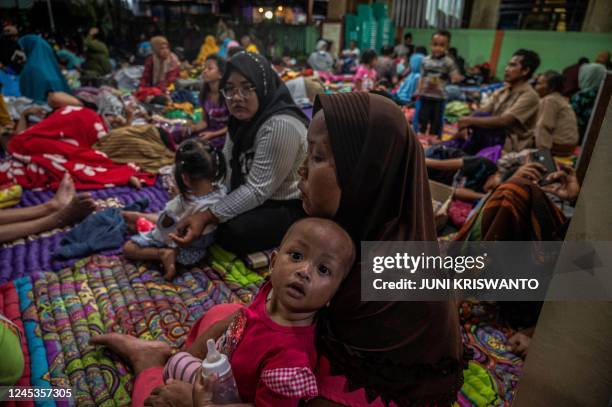 People take temporary shelter in a room at a community hall in Candipuro village following Mount Semeru's volcanic eruption in Lumajang, East Java on...