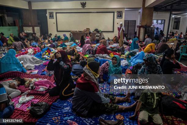 People take temporary shelter in a room at a community hall in Candipuro village following Mount Semeru's volcanic eruption in Lumajang, East Java on...