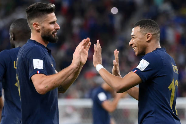 France's forward Kylian Mbappe celebrates scoring his team's second goal with France's forward Olivier Giroud during the Qatar 2022 World Cup round...
