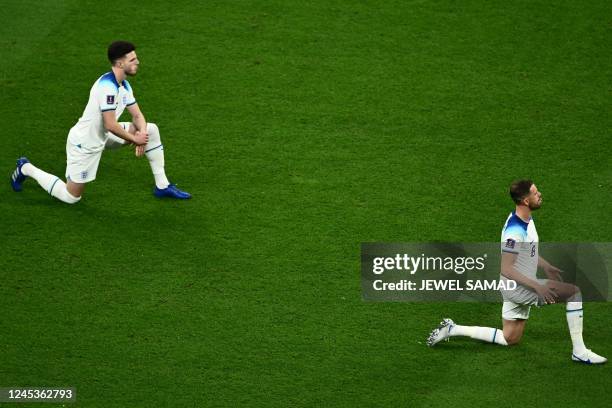 England's midfielder Declan Rice and England's midfielder Jordan Henderson take the knee prior to the Qatar 2022 World Cup round of 16 football match...