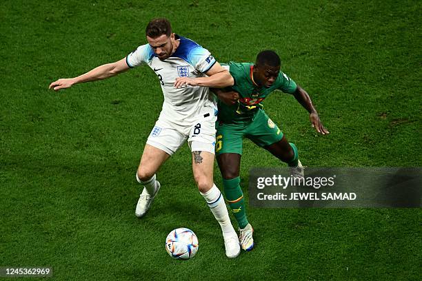 England's midfielder Jordan Henderson fights for the ball with Senegal's midfielder Nampalys Mendy during the Qatar 2022 World Cup round of 16...