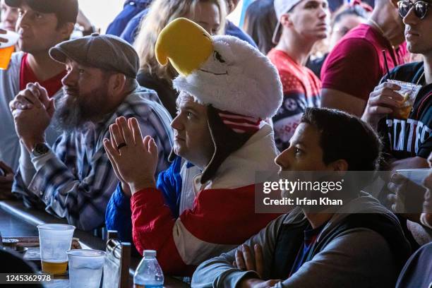Hermosa Beach, CA Eyes of Robbie Crauder, center, in bald eagle head gear and others are glued on TV screens watching U.S. Men's national team...
